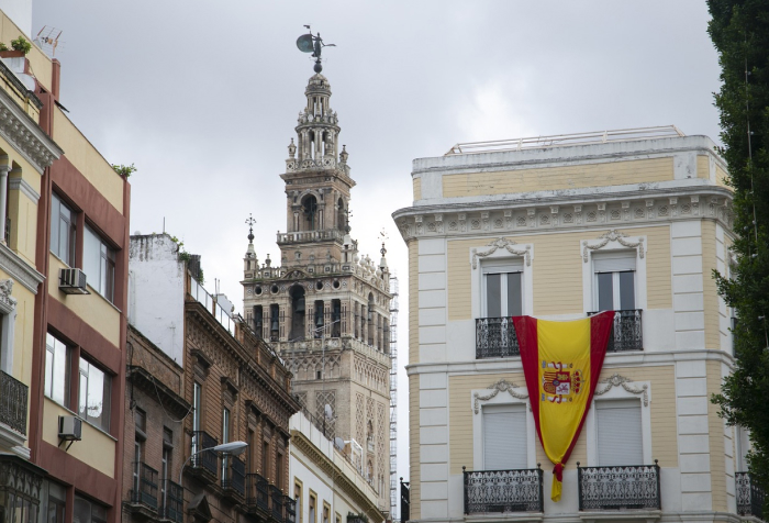 Street view of historic buildings in Spain with a Spanish flag hanging, highlighting best countries to live in 2025 rankings. Street view of historic buildings in Spain with a Spanish flag hanging, highlighting best countries to live in 2025 rankings.