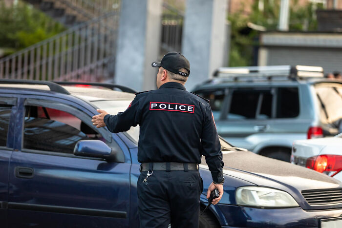 Police officer directing traffic outdoors, highlighting professions that attract the most awful people in society.