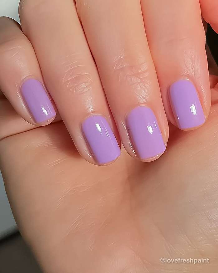 Close-up of nails painted in glossy lilac polish showcasing 2025’s hottest summer nails trend.