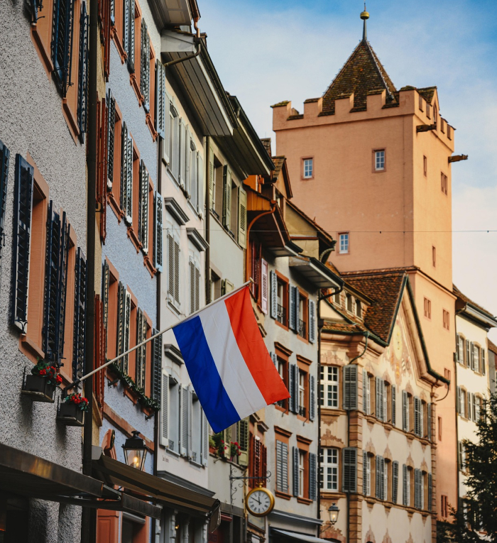 Street view in a top-ranked European country, showing traditional buildings and a vibrant flag, representing best countries to live. Street view in a top-ranked European country, showing traditional buildings and a vibrant flag, representing best countries to live.