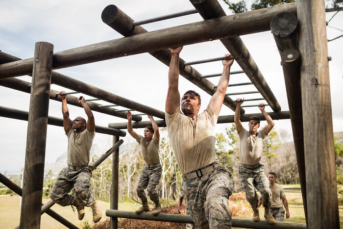 A group of men in military uniforms navigating an obstacle course, illustrating professions attracting the most awful people.