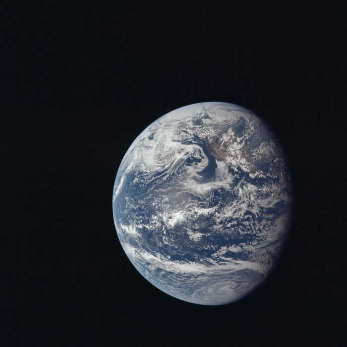 View of Earth from space captured in an Apollo mission photo showing detailed cloud formations over the planet.