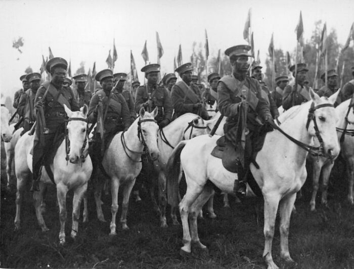 African American soldiers on horseback in historic military uniforms representing African American military history.