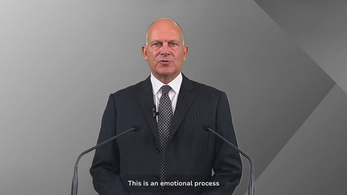 Expert in a dark suit and tie speaking at a podium, sharing theory on simple mistake in Air India crash investigation. Expert in a dark suit and tie speaking at a podium, sharing theory on simple mistake in Air India crash investigation.