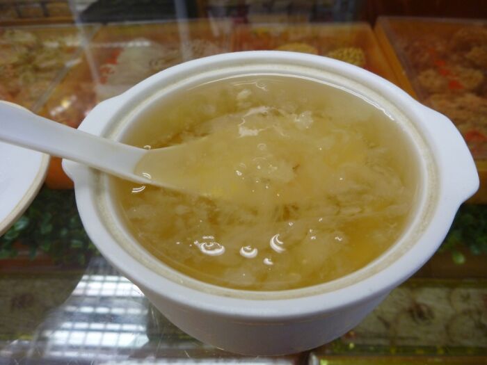 Close-up of a white bowl with a spoon containing a gelatinous food item, one of the surprising foods banned in the USA.