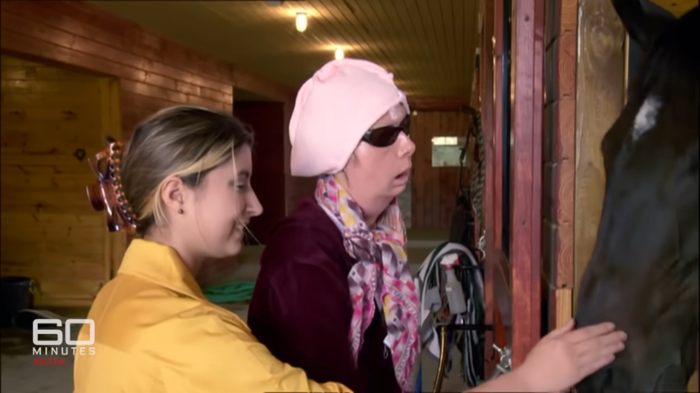 Woman whose face was torn apart by chimpanzee touching a horse with assistance, revealing her appearance after face transplant. Woman whose face was torn apart by chimpanzee touching a horse with assistance, revealing her appearance after face transplant.