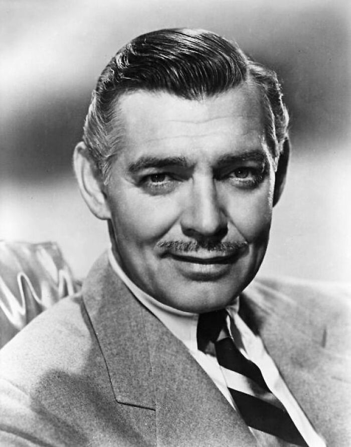 Black and white portrait of a smiling 20th century star wearing a suit, representing stars lost too soon in history.