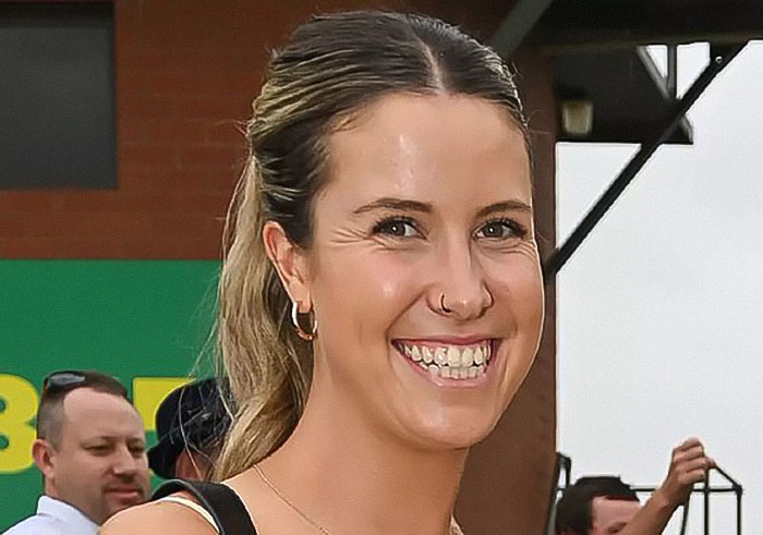 Young woman with a ponytail smiling outdoors, related to news about woman who set male friend on fire over misogynistic comment. Young woman with a ponytail smiling outdoors, related to news about woman who set male friend on fire over misogynistic comment.