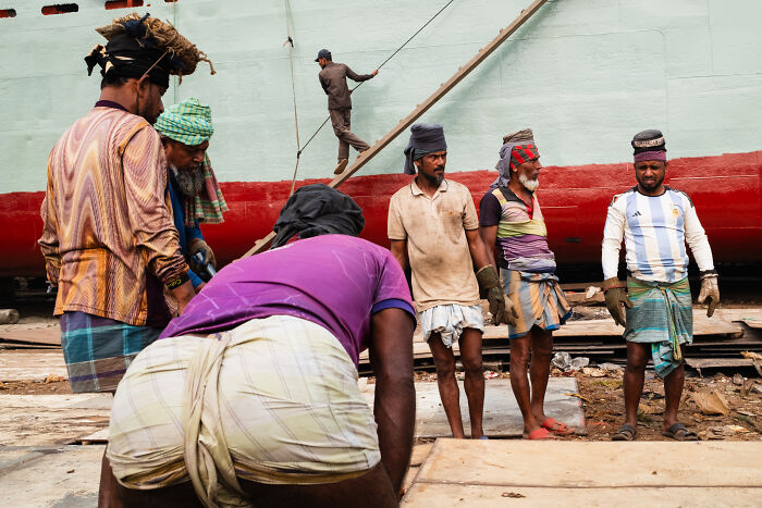 Group of men working at a shipyard captured in candid street moments full of emotion by a photographer traveling the world.