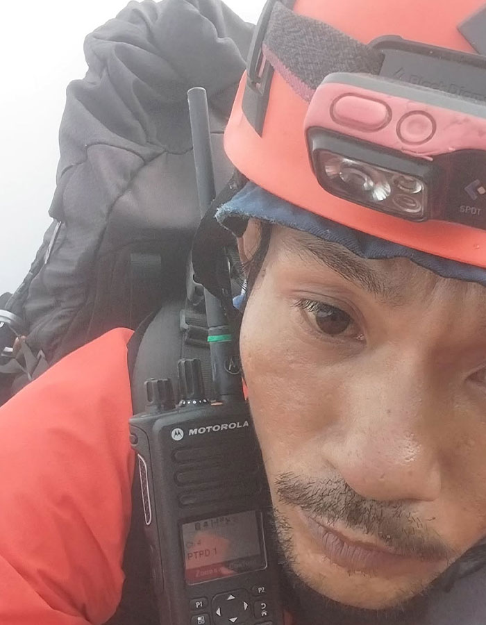 Rescue worker wearing helmet and radio during recovery mission at 1600ft-deep active volcano, hero guide recovers tourist's body Rescue worker wearing helmet and radio during recovery mission at 1600ft-deep active volcano, hero guide recovers tourist's body