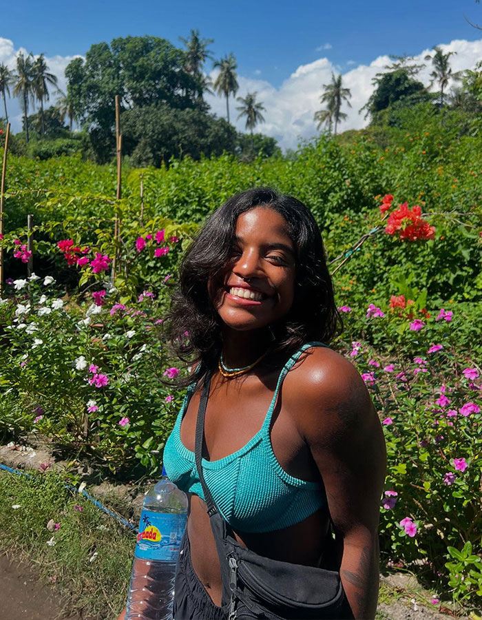 Young woman smiling outdoors in a garden, related to hero guide recovering tourist's body from active volcano. Young woman smiling outdoors in a garden, related to hero guide recovering tourist's body from active volcano.