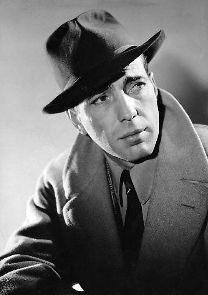 Black and white portrait of a 20th century star wearing a hat and coat, symbolizing stars lost too soon.