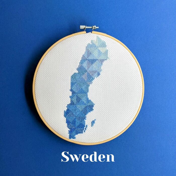 Cross-stitched map of Sweden in shades of blue, displayed in an embroidery hoop on a blue background.