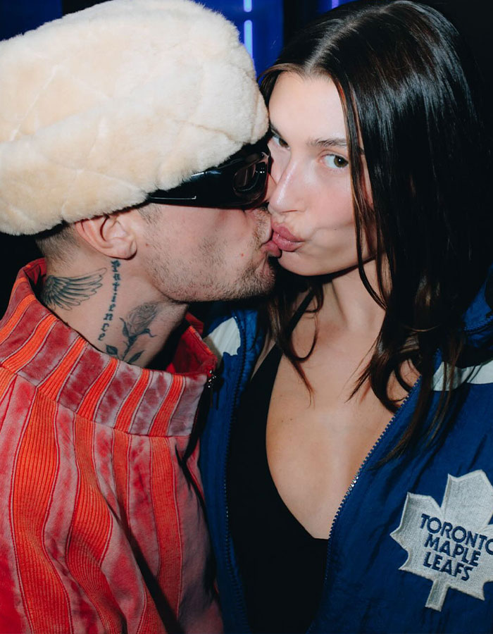 Justin Bieber kissing a woman while wearing a furry hat and sunglasses, showcasing his real dad and real man image. Justin Bieber kissing a woman while wearing a furry hat and sunglasses, showcasing his real dad and real man image.