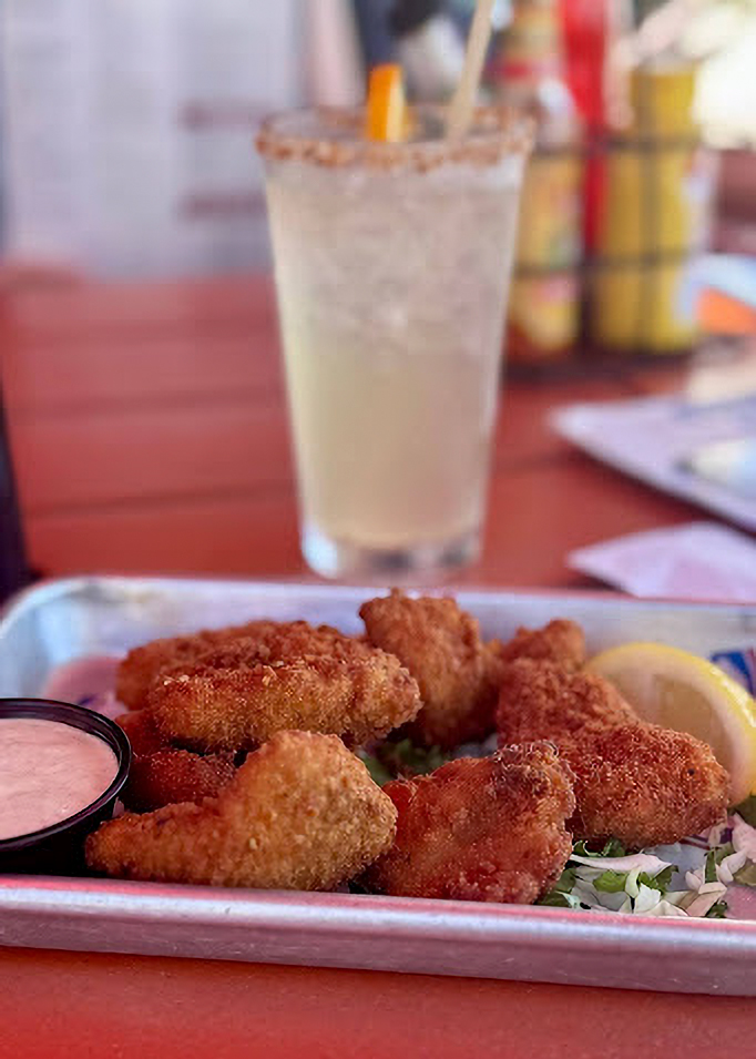 Fried seafood platter with dipping sauce and cocktail on a table at Siesta Key beach restaurant. Fried seafood platter with dipping sauce and cocktail on a table at Siesta Key beach restaurant.