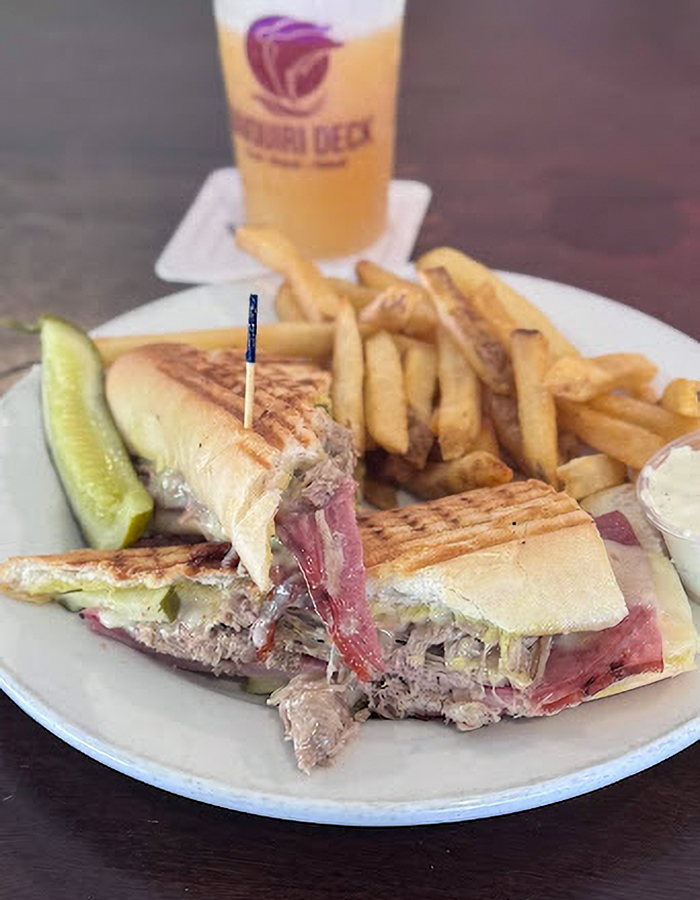 Grilled Cuban sandwich with fries, pickle, and dipping sauce served at Siesta Key's popular beachside eatery. Grilled Cuban sandwich with fries, pickle, and dipping sauce served at Siesta Key's popular beachside eatery.