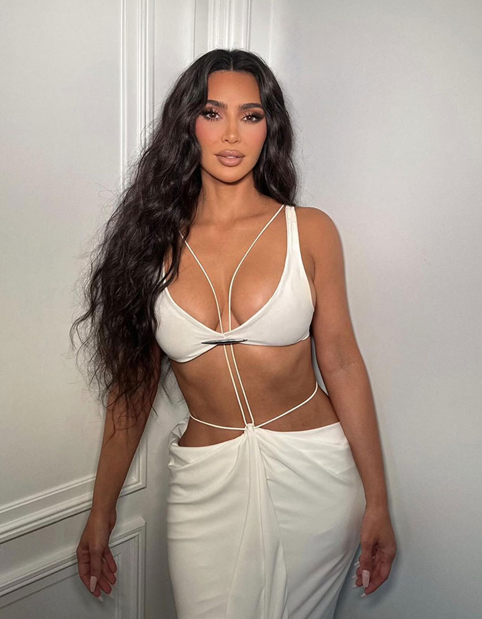 Kim Kardashian posing in a white outfit in a throwback photo sparking discussions on her plastic surgeries. Kim Kardashian posing in a white outfit in a throwback photo sparking discussions on her plastic surgeries.