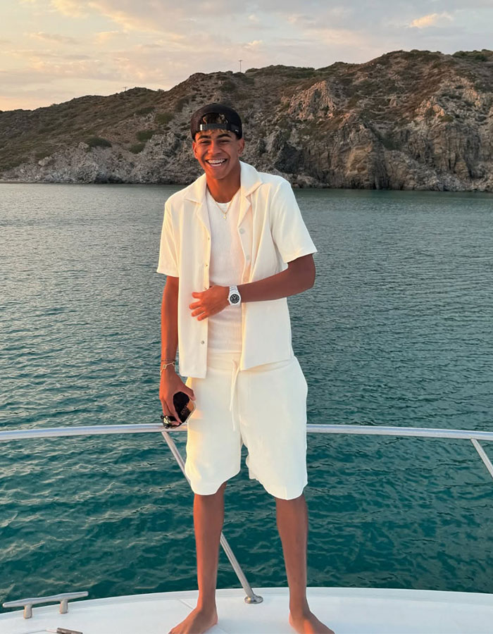 Young man smiling on a boat near rocky shore, related to controversy after woman called out for relationship with 17YO. Young man smiling on a boat near rocky shore, related to controversy after woman called out for relationship with 17YO.