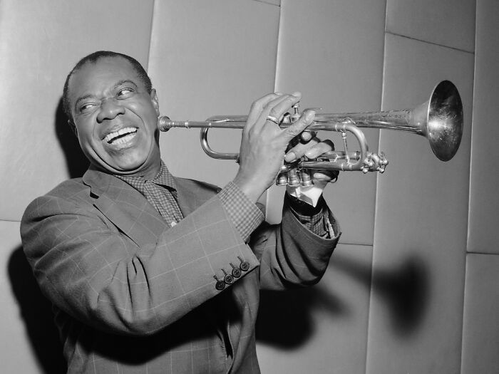 Legendary musician playing trumpet, capturing a key Harlem Renaissance moment with joyful expression and vintage style.