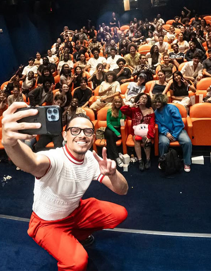 Hamilton star taking a selfie with a large audience in a theater setting during a show performance event. Hamilton star taking a selfie with a large audience in a theater setting during a show performance event.