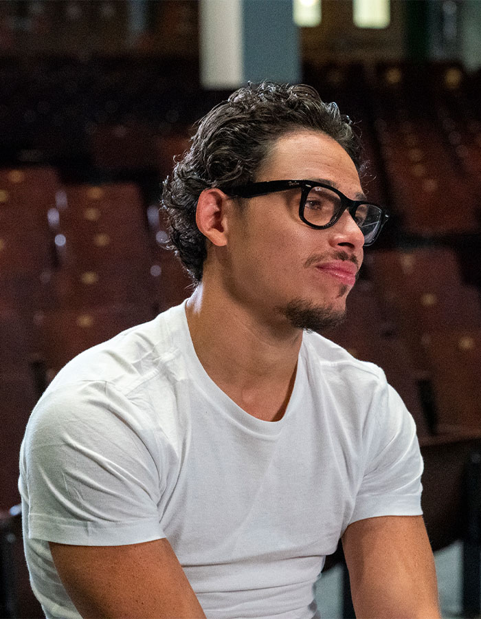 Hamilton star wearing glasses and white shirt seated in theater, reacting to Madonna blasted for disrespectful behavior during show. Hamilton star wearing glasses and white shirt seated in theater, reacting to Madonna blasted for disrespectful behavior during show.