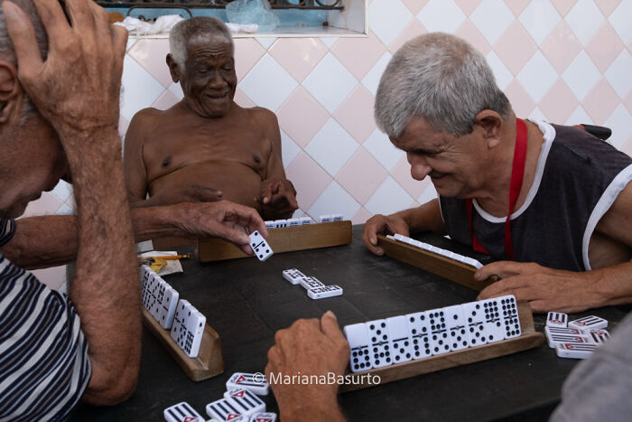 Elderly men enjoying a game of dominoes, capturing unseen realities through the lens of a documentary photographer.