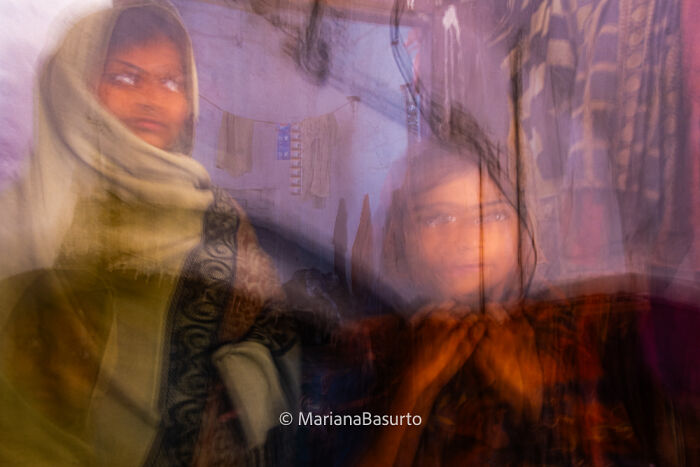 Blurred photo of two women indoors, capturing the unseen realities of our world through artistic photography.