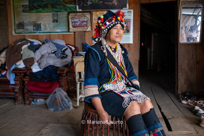 Ethnic woman in traditional attire sitting indoors, captured in a revealing photograph showcasing unseen realities of our world.