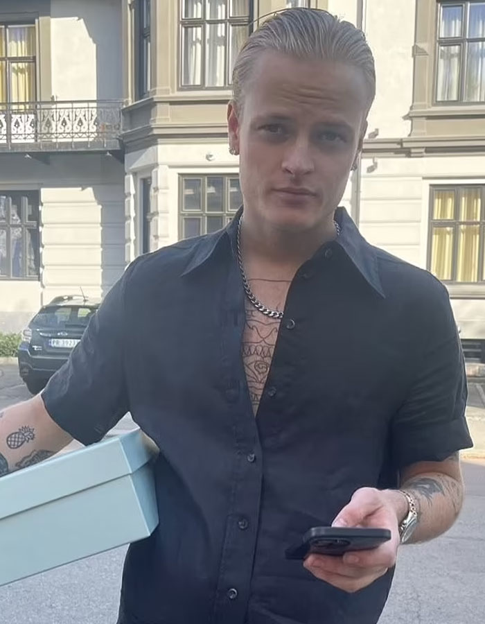 Young man outdoors, holding a box and phone, representing Norwegian Crown Princess’s son facing charges including violent assaults. Young man outdoors, holding a box and phone, representing Norwegian Crown Princess’s son facing charges including violent assaults.