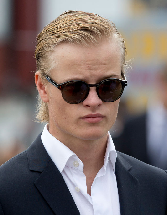 Young man wearing dark sunglasses and a black suit, representing Norwegian Crown Princess’s son facing multiple charges.