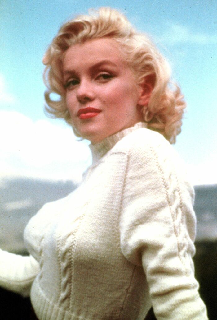 Blonde woman in a white sweater posing outdoors, representing one of the stars we lost too soon in the 20th century.