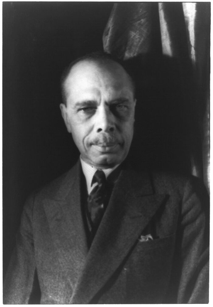 Portrait of a man in a dark suit highlighting key Harlem Renaissance moments and cultural influence.