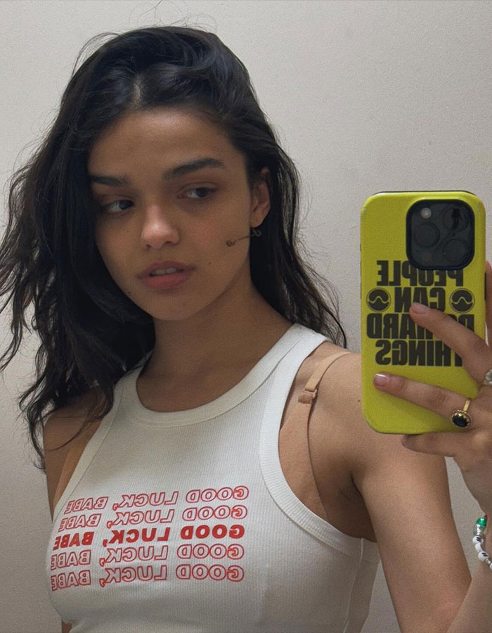 Rachel Zegler taking a mirror selfie in a white tank top during a live show that sparked fan outrage. Rachel Zegler taking a mirror selfie in a white tank top during a live show that sparked fan outrage.