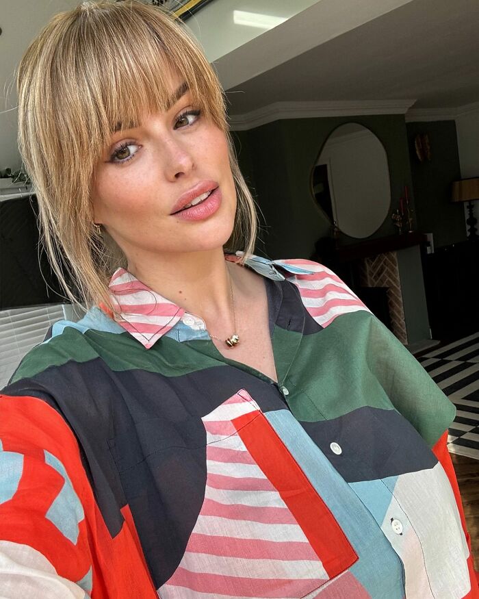 Model wearing colorful shirt indoors, representing F-cup chest breast reduction surgery after walking discomfort.