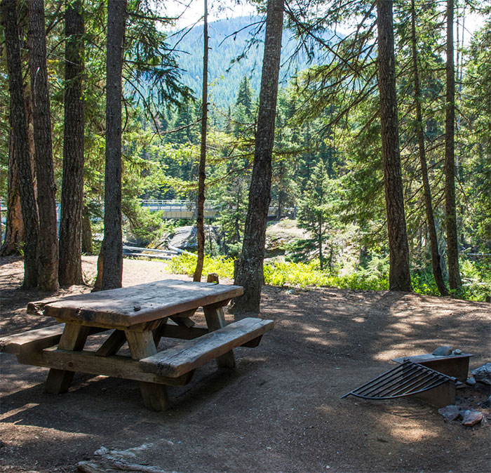 Picnic table in a forested area representing Travis Decker’s neighbor recalling a weird encounter before girls were found lifeless.