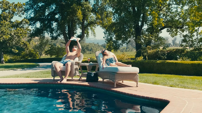 Young adults relaxing by a pool in a luxurious backyard, highlighting nepo grandbaby lifestyle and public criticism. Young adults relaxing by a pool in a luxurious backyard, highlighting nepo grandbaby lifestyle and public criticism.