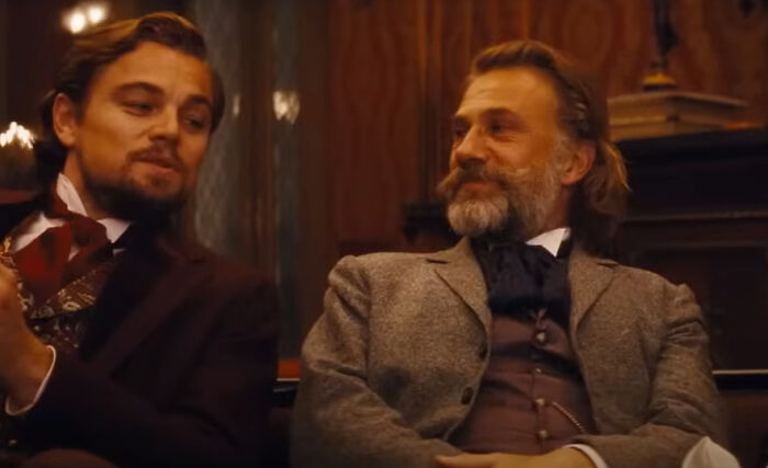 Two men in vintage attire having a conversation, representing iconic scenes from greatest films of the new millennium.