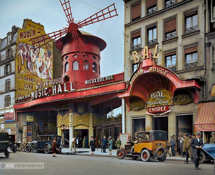 Colorized historical photo of Moulin Rouge music hall and vintage cars on a Paris street from magical historical photos collection.
