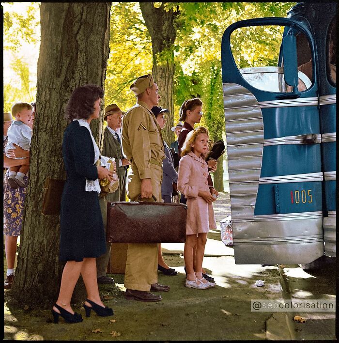 Colorized historical photo showing a group of people including a soldier boarding a vintage bus under autumn trees.