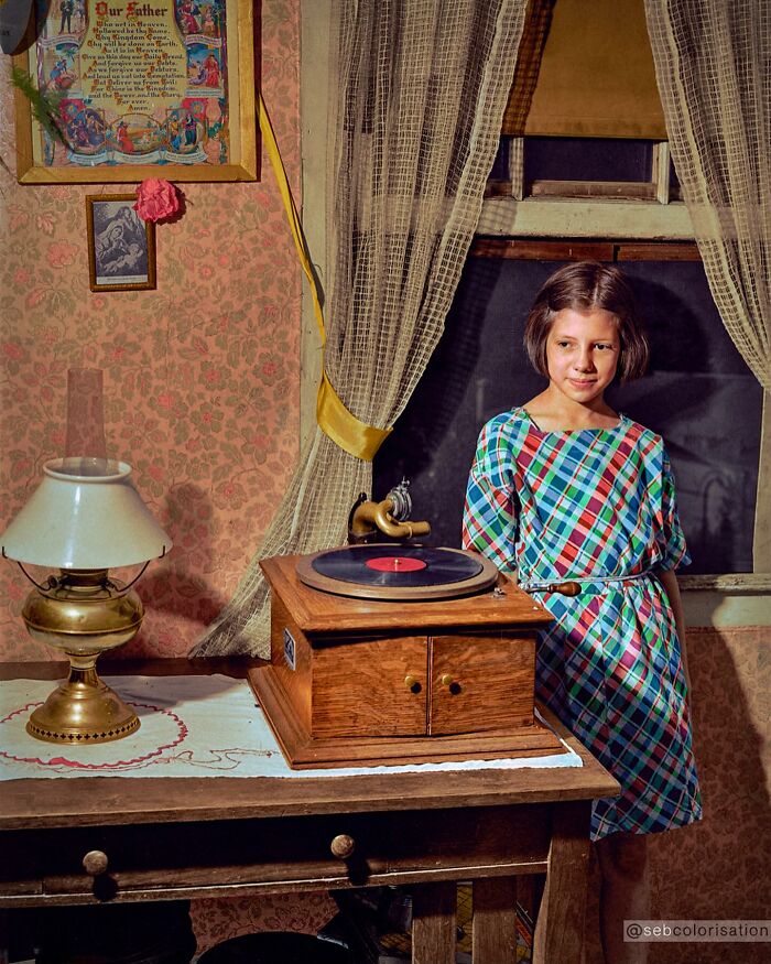 Young girl in a vintage room standing beside an old gramophone, colorized historical photo by a viral artist
