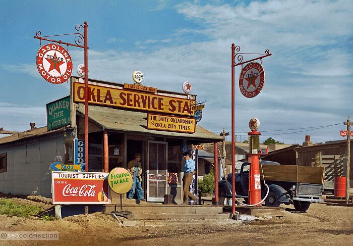 Colorized historical photo of an Oklahoma service station with vintage Texaco gasoline signs and people at the entrance.