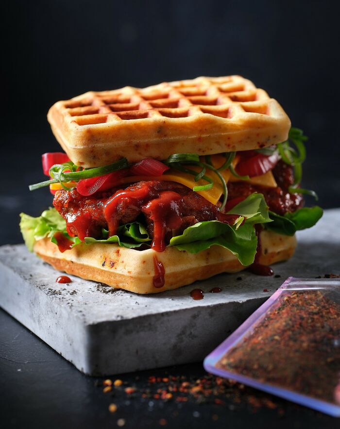 Waffle sandwich with lettuce, cheese, and barbecue sauce, a mouthwatering food photo by Kai Stiepel that might make you hungry instantly