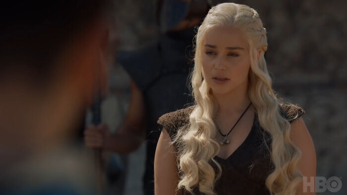 Woman with long blonde hair in medieval costume discussing baby names that secretly weird them out in a dramatic scene