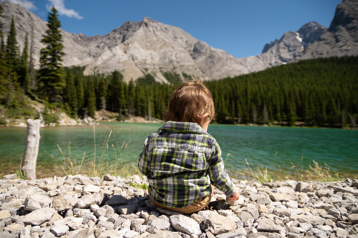 Toddler by lake and mountains, illustrating baby names that people find totally acceptable but secretly weird.
