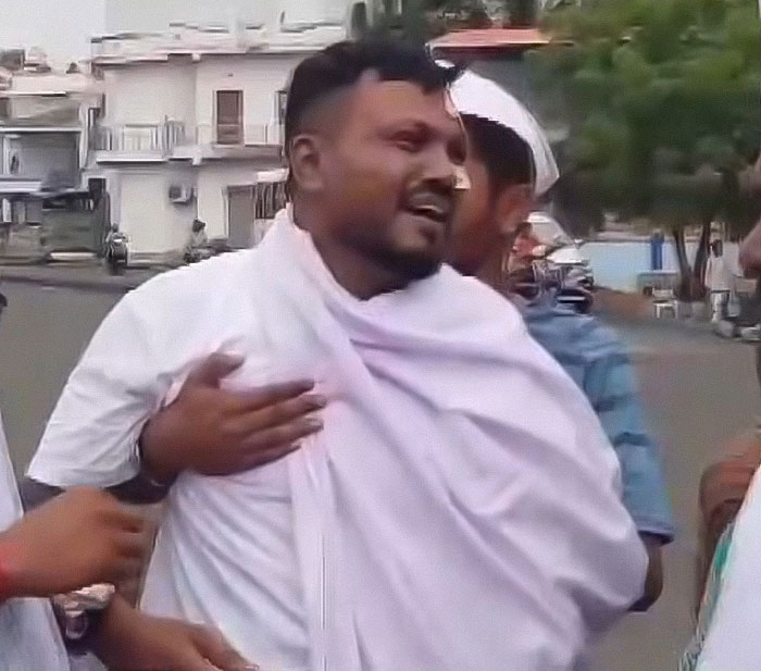 Man wrapped in a white cloth emotionally expressing survivor's guilt as Air India survivor on a street with blurred background. Man wrapped in a white cloth emotionally expressing survivor's guilt as Air India survivor on a street with blurred background.