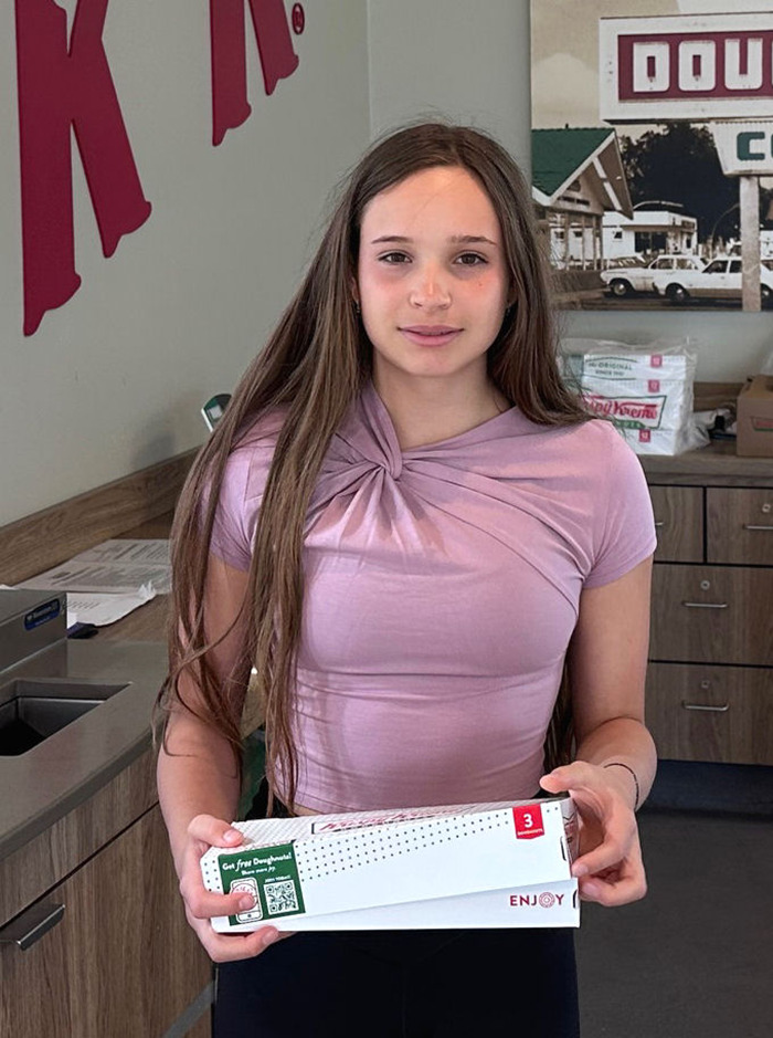 Teen girl found alive after six weeks missing, standing indoors holding a box, wearing a light purple top and long hair. Teen girl found alive after six weeks missing, standing indoors holding a box, wearing a light purple top and long hair.