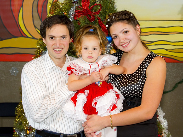 Family smiling together celebrating near a decorated Christmas tree, symbolizing relief after missing girl found alive. Family smiling together celebrating near a decorated Christmas tree, symbolizing relief after missing girl found alive.