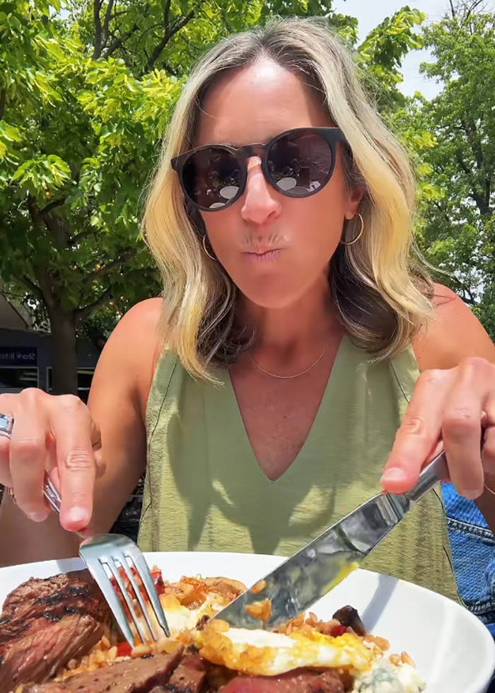 Woman eating steak and eggs with cutlery outdoors, illustrating Americans primitive way of eating with cutlery debate. Woman eating steak and eggs with cutlery outdoors, illustrating Americans primitive way of eating with cutlery debate.