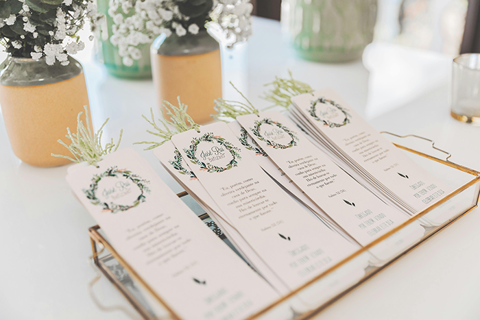 Wedding program cards arranged on a tray with floral decorations, symbolizing family wedding legacy and young mom attendance.