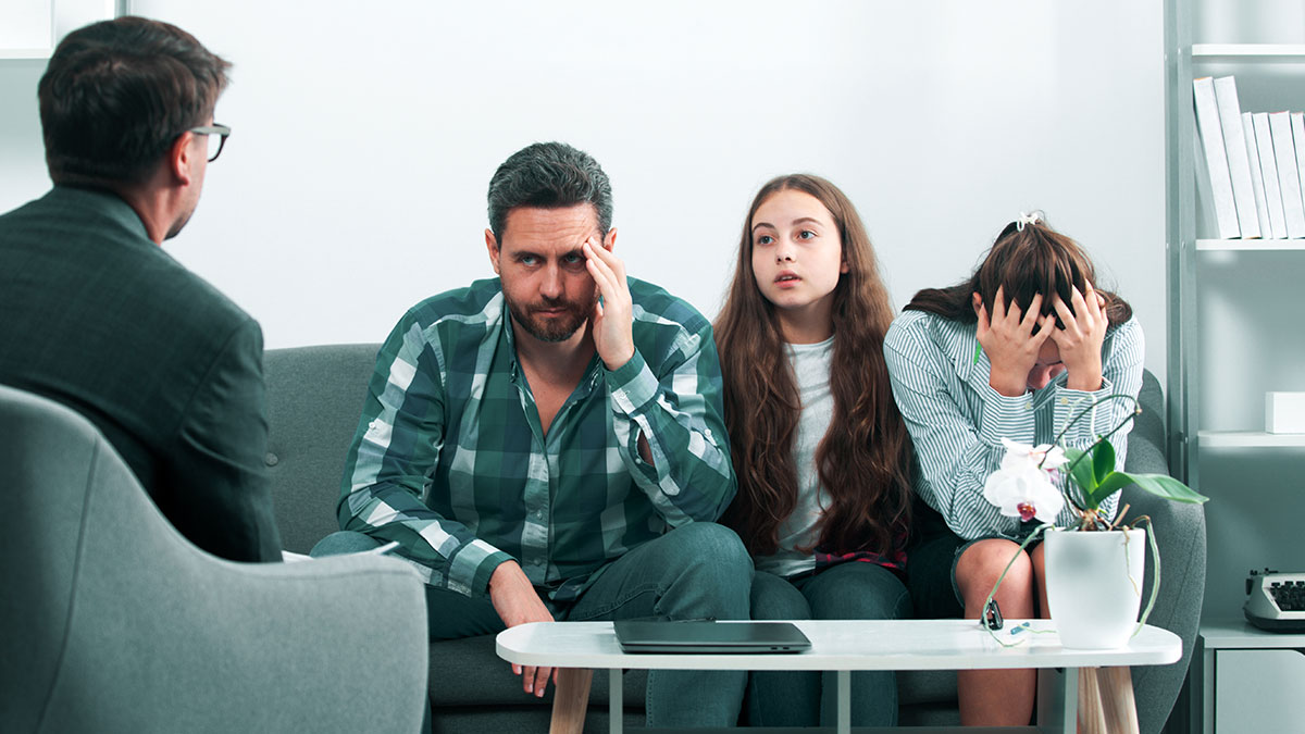 Family in therapy session with concerned teen refusing to take classes about babysitting autistic stepbrother at home